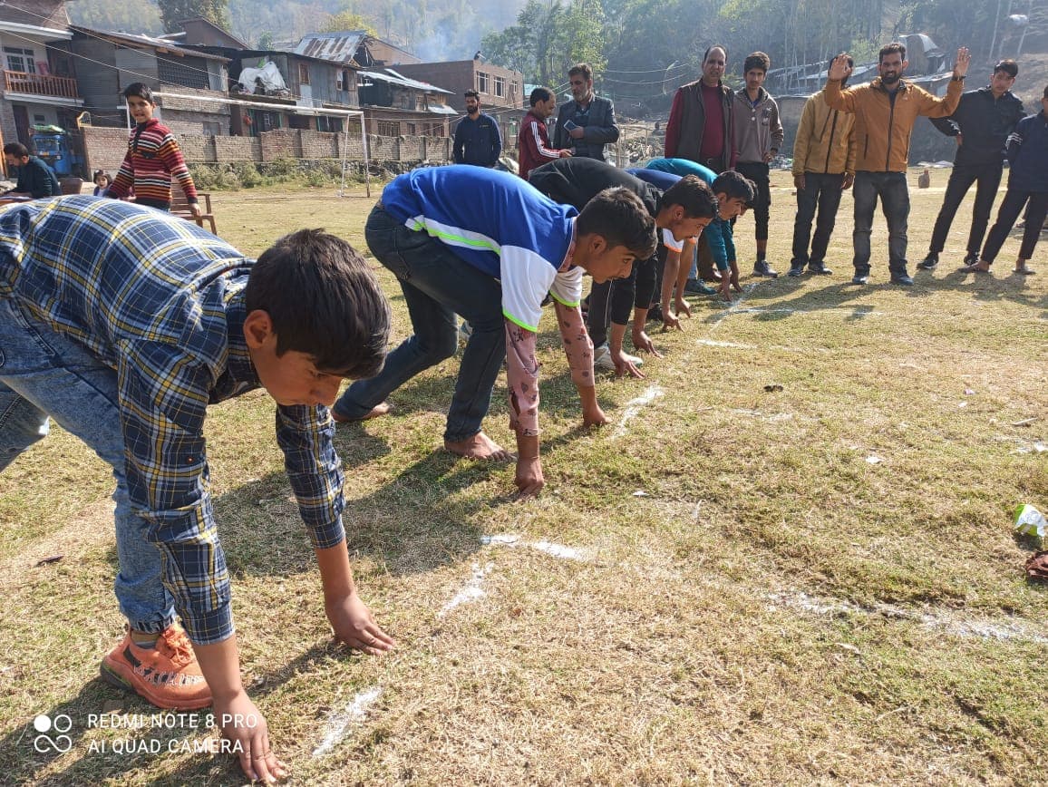 Boys lining up for a sprint race on a village field during a KOSHISH community sports day